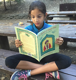 Girl reading The Wisdom of Ahmad Shah