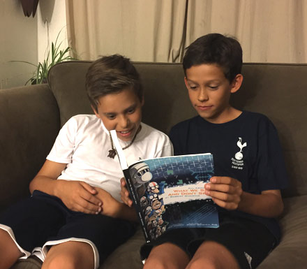 2 boys reading the book What We See and Don't See